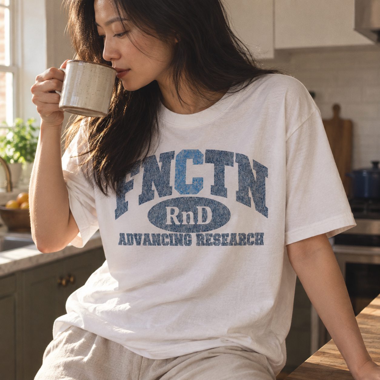 Close on the navy varsity print of the White tee over a morning coffee