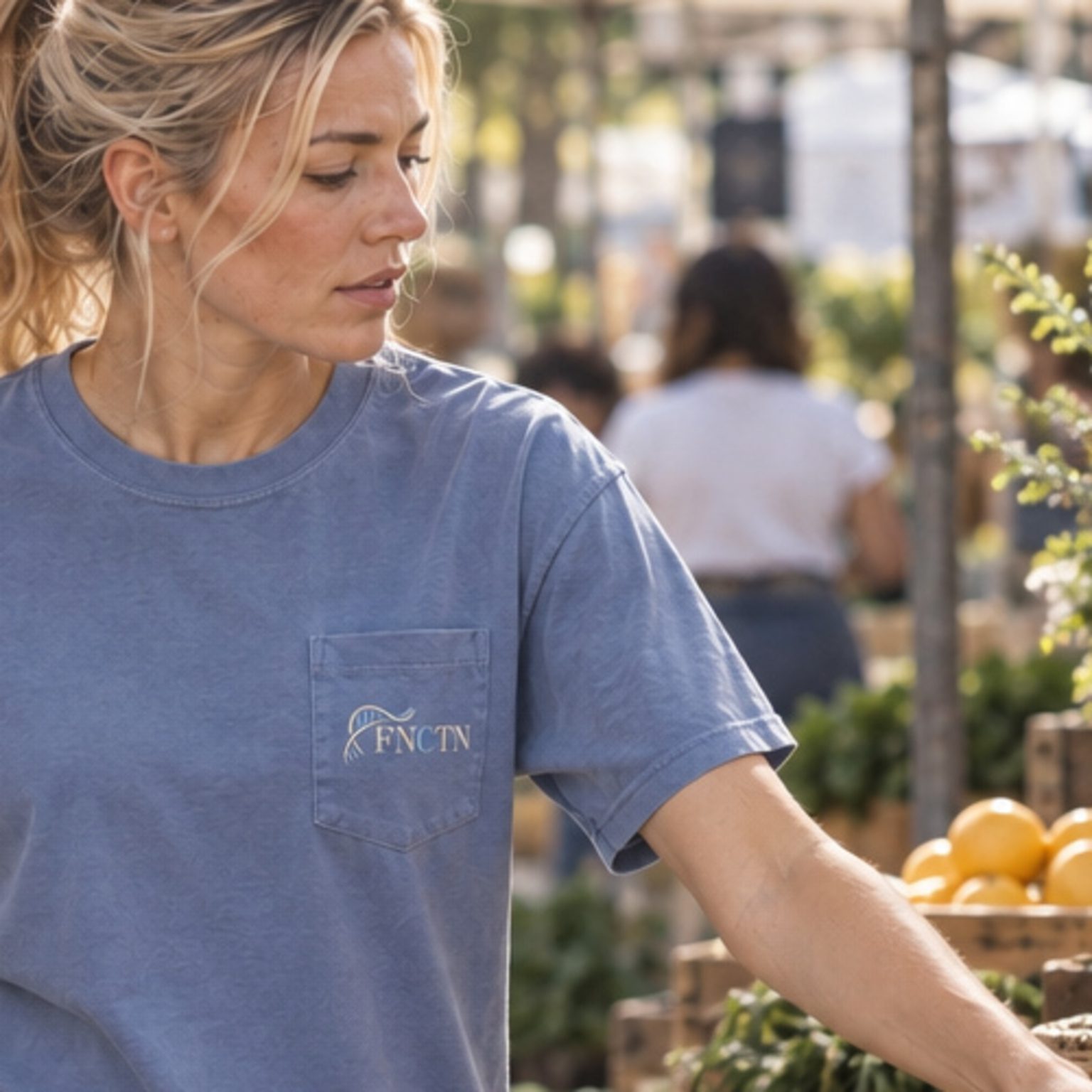 Close on the chest pocket of the Washed Denim Pocket Tee, the helix and FNCTN